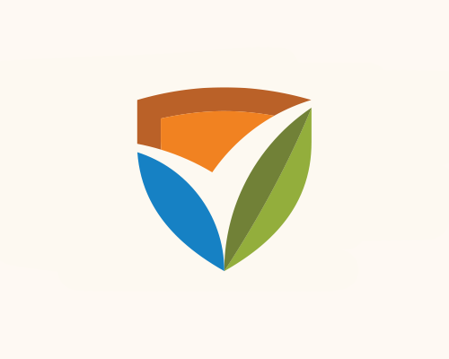 Two workers in orange vests walk along a fenced construction site.